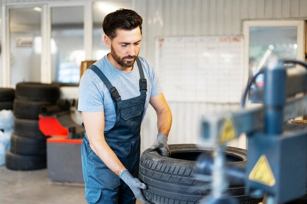 mechanic-picking-up-car-tire-seasonal-change-garage